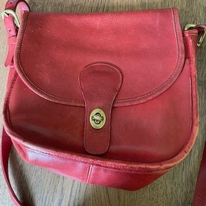 Vintage woman’s Coach crossbody red all leather bag with signs of wear